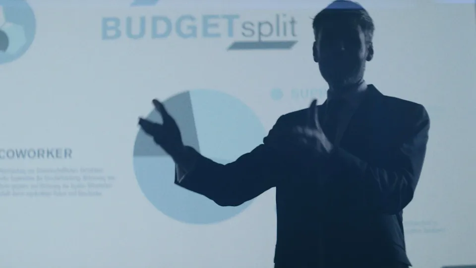 Silhouette eines Geschäftsmannes, der auf eine Präsentation mit dem Logo "BUDGETsplit" und einem Kreisdiagramm zeigt.