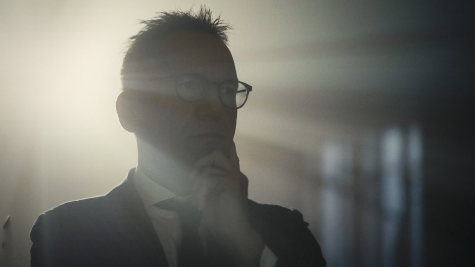 Silhouette einer Person mit Brille und kurzem Haar im Gegenlicht, Profil von der Seite aufgenommen.