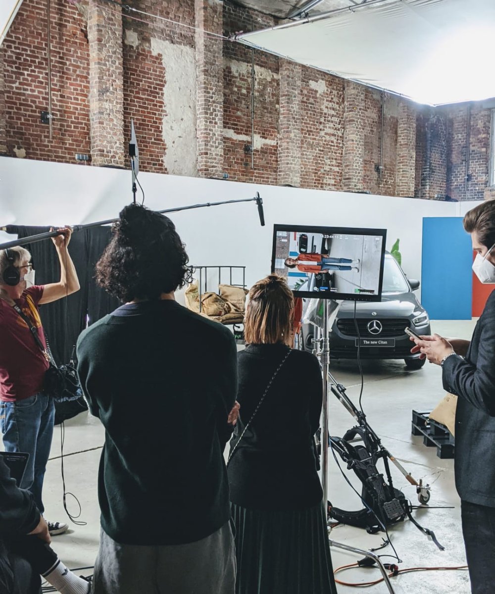 Filmteam bei Werbedreh für Mercedes-Benz in industriellem Loft-Studio mit Backsteinwand und Beleuchtungsequipment