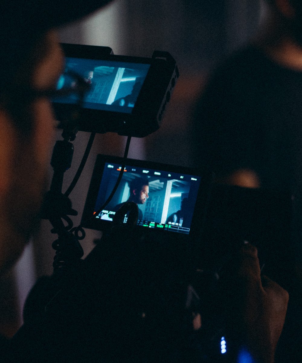 Filmkamera mit zwei Monitoren zeigt Live-Aufnahme einer Szene während eines Filmdrehs am Set