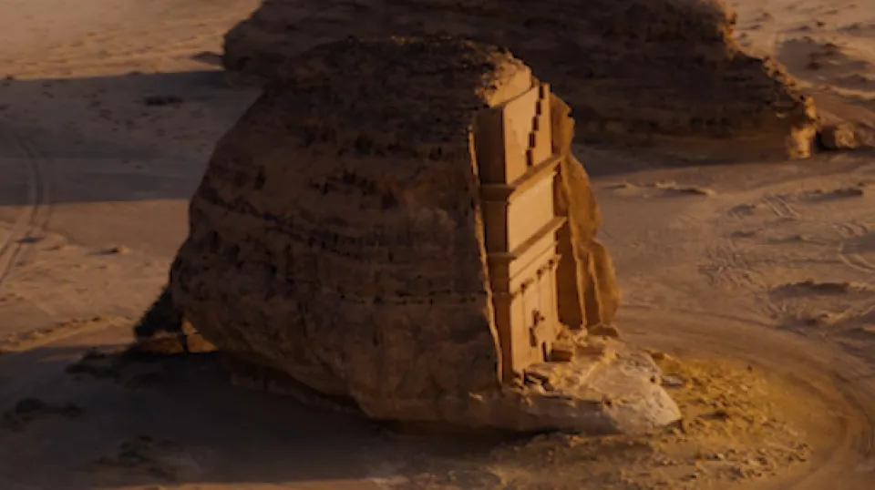 Antike nabatäische Grabfassade in einen freistehenden Sandsteinfelsen gemeißelt in der Wüstenlandschaft von Mada'in Salih, Saudi-Arabien, bei warmem Abendlicht.